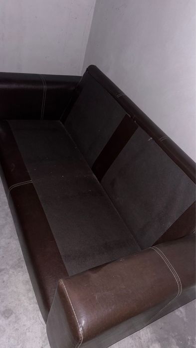 Sofá castanho em pele, com encostos e assentos em almofadas,.
