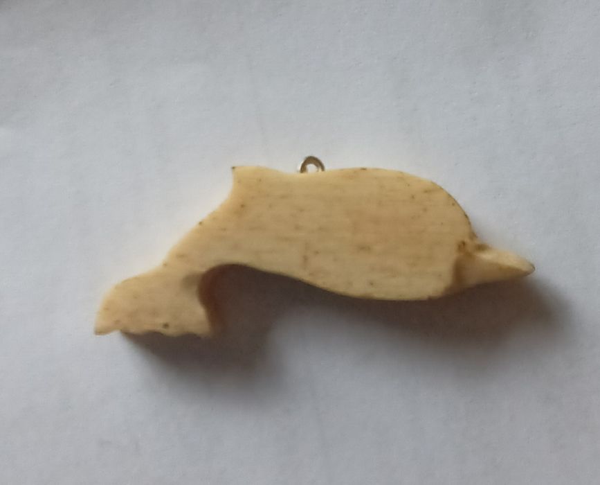Golfinho  em osso de baleia.
Tem uma pintura alusiva à ilha do Pico. Data de 1989.
Mede aproximadamente 5 cm.