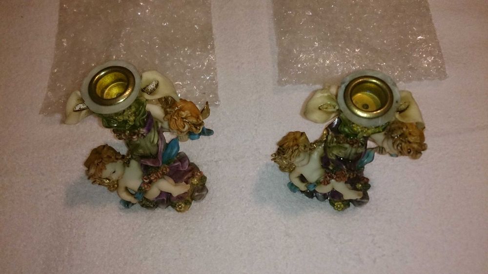 2 castiçais (para colocar velas) com anjos decorativos