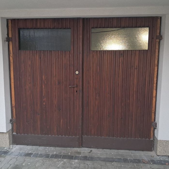 Solidne drzwi garażowe drewniane – dwuskrzydłowe z przeszkleniem