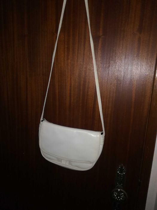 Mala branca, pequena, com alça comprida, dá para pôr ao pescoço.