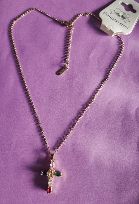 Colar dourado, em aço, com cruz colorida. Tem extensor.