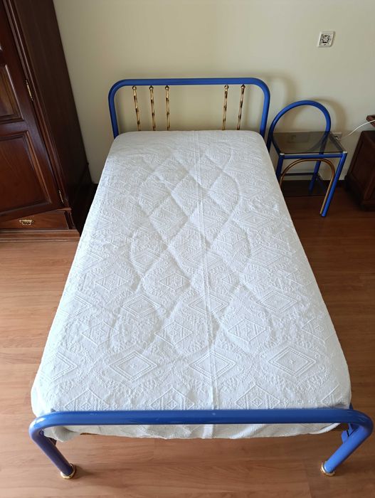 Cama solteiro azul e mesa de cabeceira