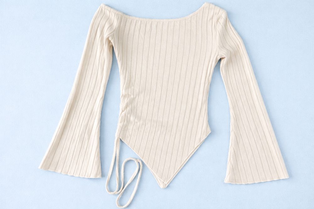 Стильна жіноча кофтинка молочного кольору з ввдкритим плечем.