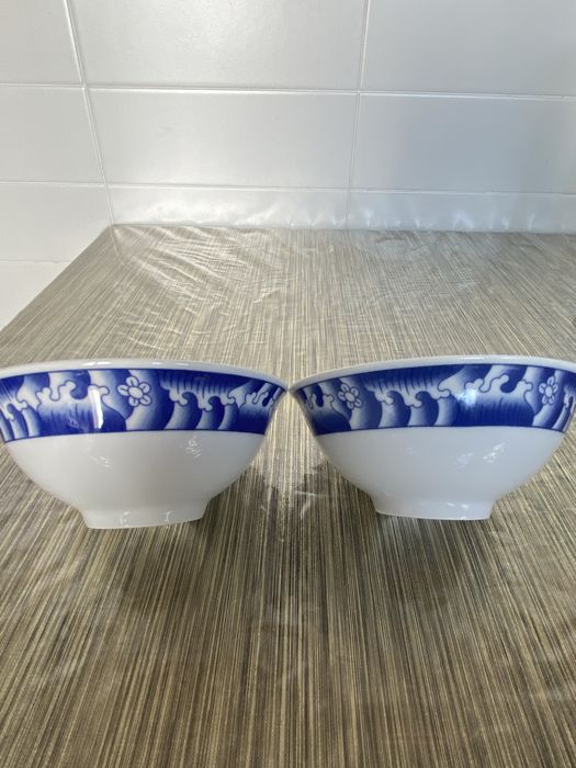 Dois pares de pratos e taças em porcelana azul e branca.