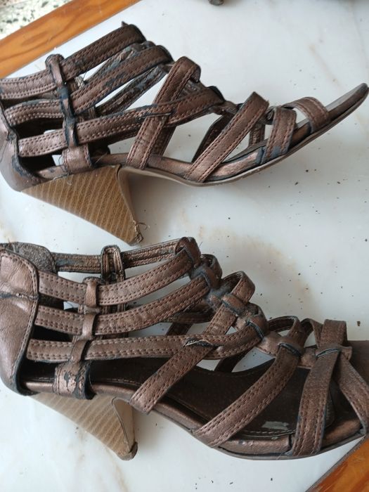 Sapatovdourado escuro de salto