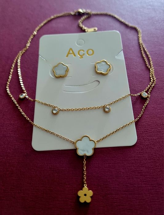 Conjunto dourado (colar duplo e brincos), em aço, com flores brancas em madrepérola.