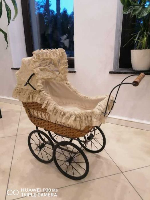 Piękny wiklinowy wózek dla lalek z ozdobną koronk