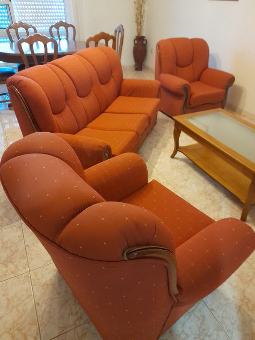 Três sofás em tons laranja.