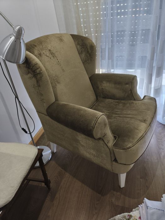 Poltrona de veludo verde e repousa pés