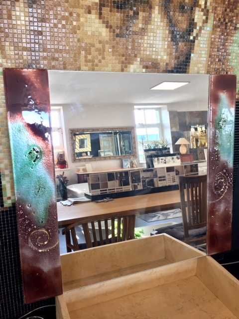 Lustro z ozdobnymi szklanymi bokami.