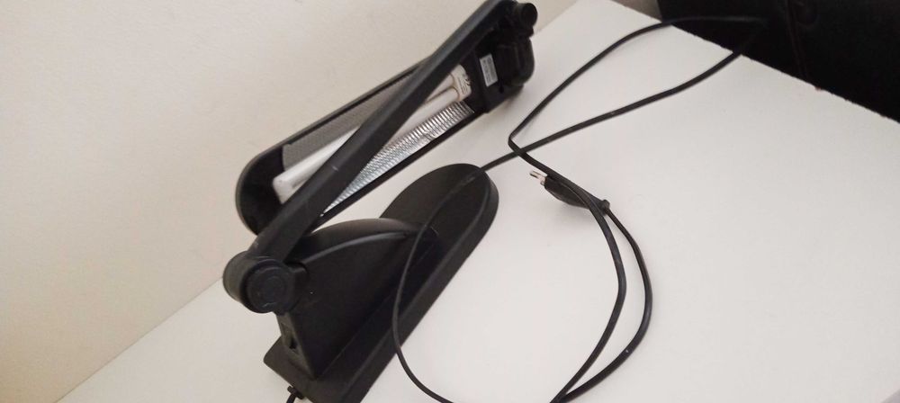 Candeeiro de secretária preto, articulado, com lâmpada.