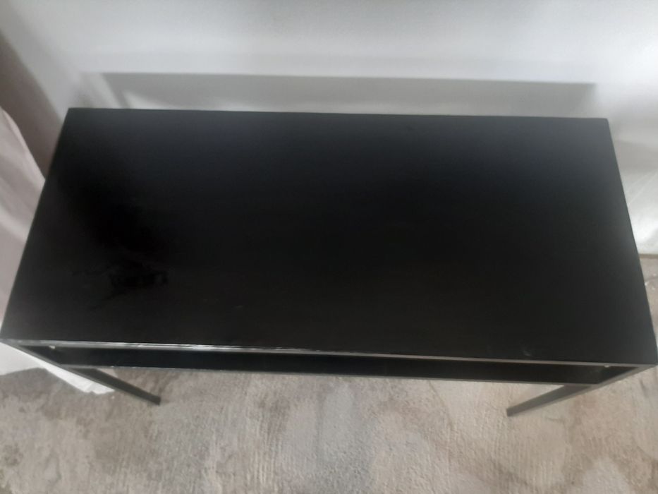 Consola em metal com uma prateleira.