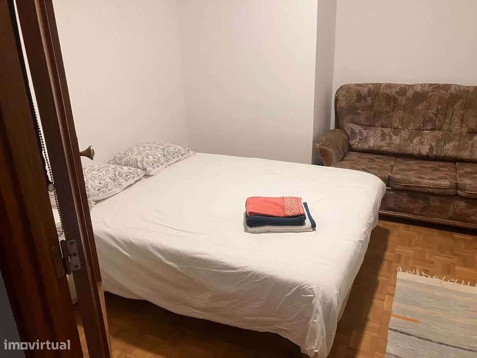 Spacious bedroom with a double bed, a desk and a couch