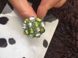 anel prateado com pedras verdes