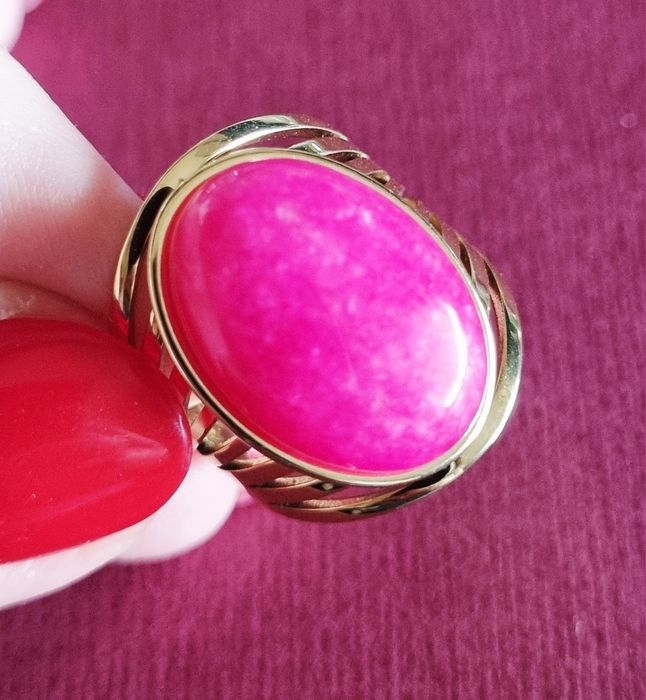 Anel dourado, em aço, com pedra oval rosa fucsia. 18/ajustável
