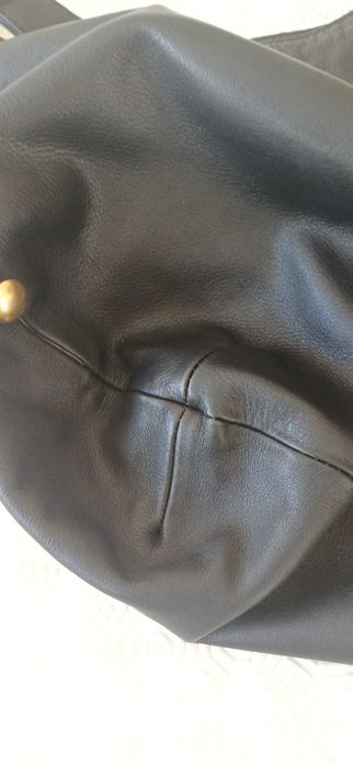 Mala preta em pele com tachas douradas