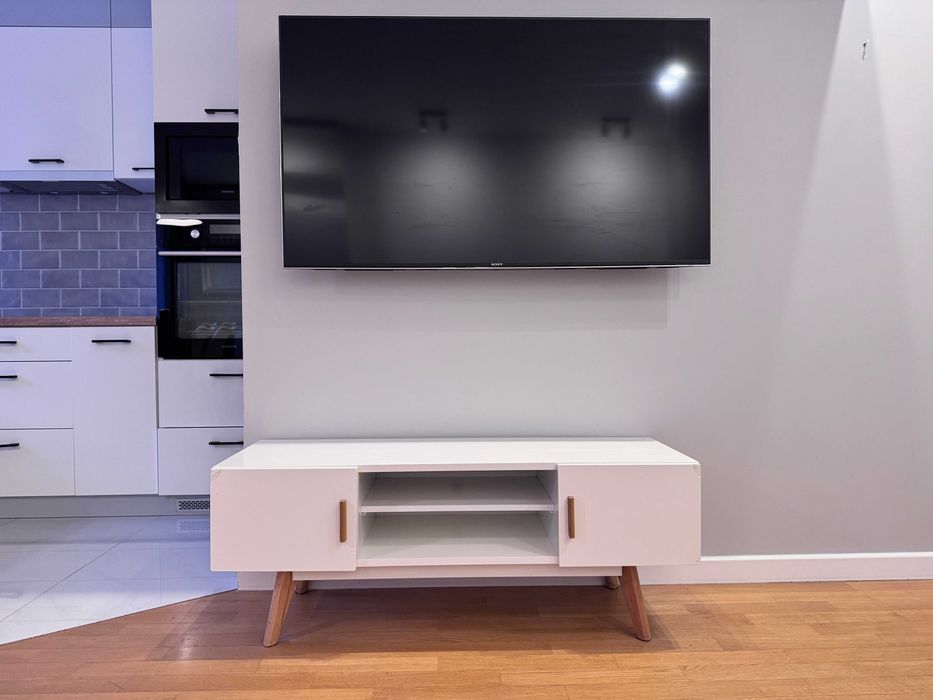 Nowoczesna szafka pod telewizor- biała, nóżki i uchwyty dąb naturalny