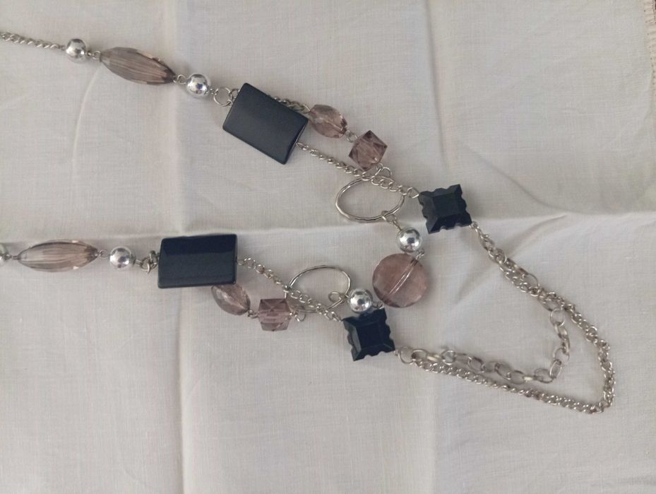 Colar em metal prateado, com aplicações pretas e cinza rosado