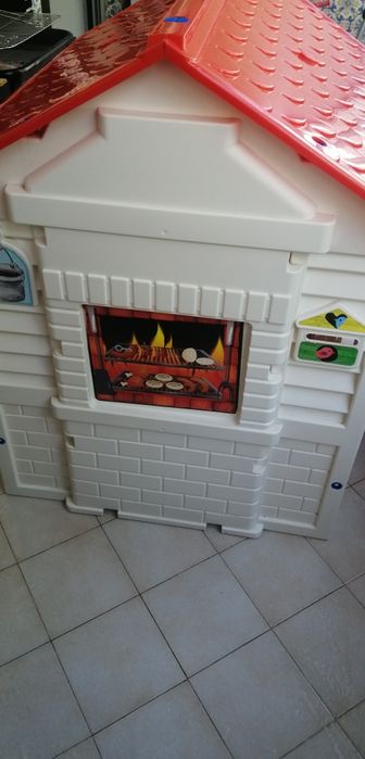 Casa de jardim de criança de plástico com telhado vermelho em bom estado