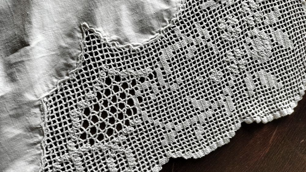 Toalha de mesa em tecido branco bordado, centro e  cantos em crochet.