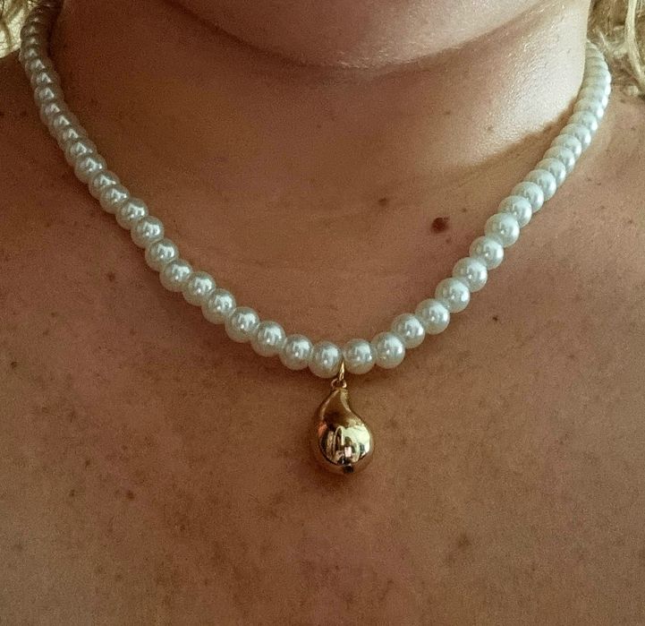 Colar de pérolas com acabamento e pingente em forma de gota, em aço.