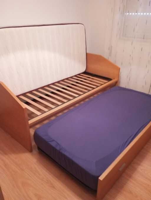 Cama dupla com colchões.