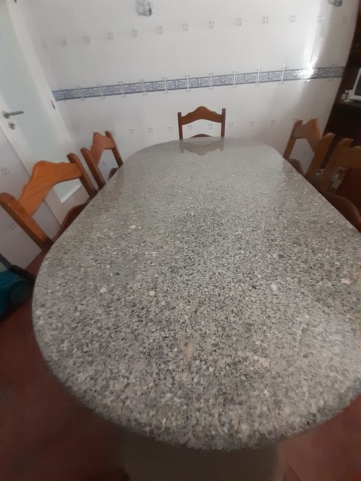Mesa de pedra com 6 cadeiras.
