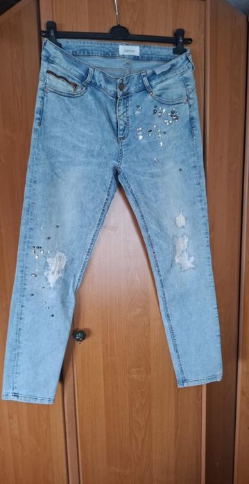 Jeansy damskie z przetarciami i ćwiekamii