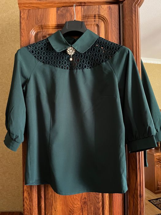Смарагдова блуза з мереживом і брошкою