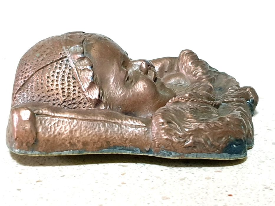 Amorosa antiga escultura de cabeça de um bebé à dormir numa almofada
