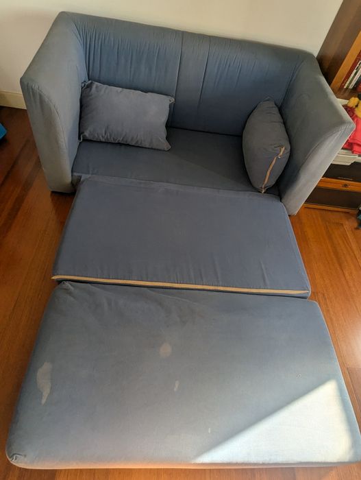Sofá cama azul com algumas manchas