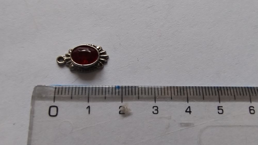 Srebrna zawieszka z czerwonym oczkiem