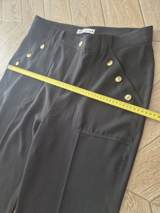 Czarne eleganckie spodnie damskie z szeroką nogawką i rzędowymi guzika