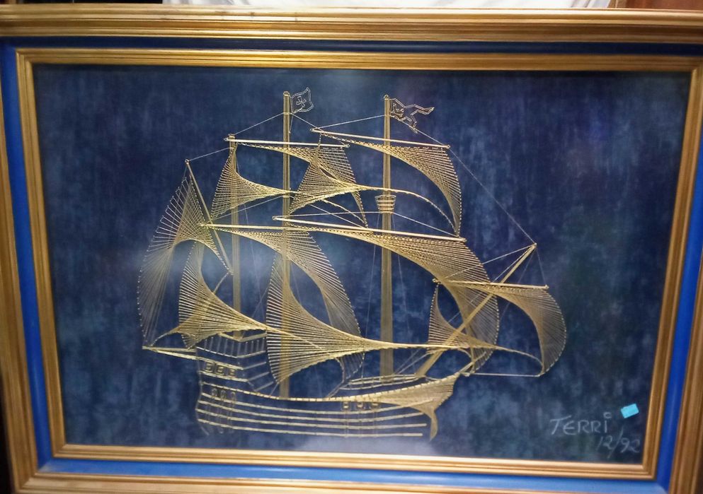 Quadro construído com fio dourado a representar uma caravela Portuguesa
