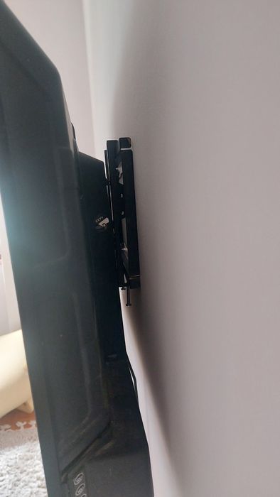 TV com suporte de parede e pés