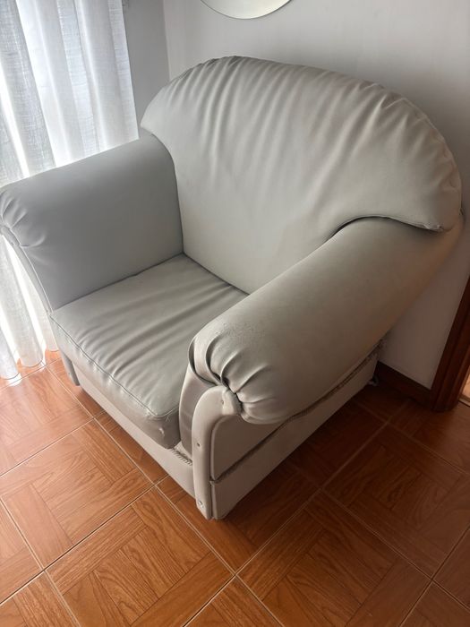 Sofá cinza confortável com marcas de uso de um lugar