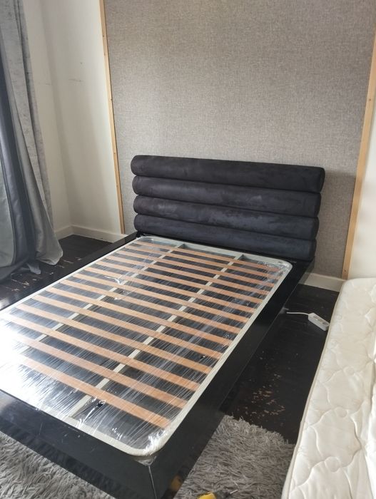 Uma cama casal com estrado e colchão