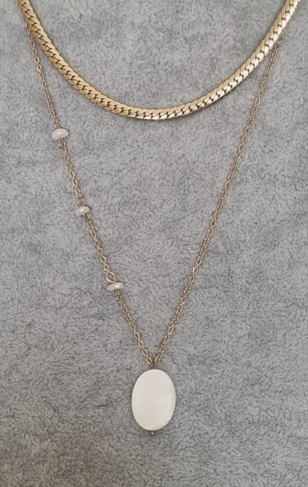 Colar duplo dourado, em aço, com pingente em madrepérola natural.