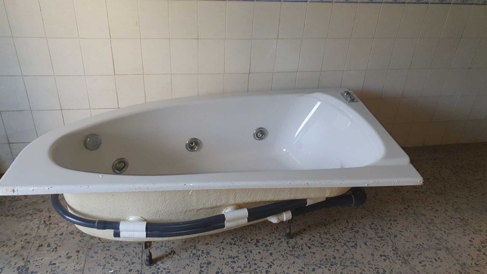 Banheira angular com sistema de hidro-massagem.