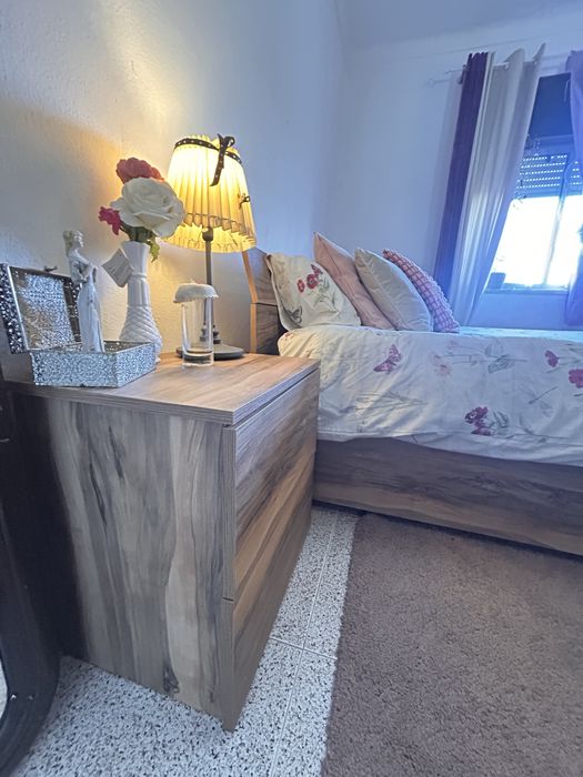 Quarto casal com mesas de cabeceiras e cómoda.