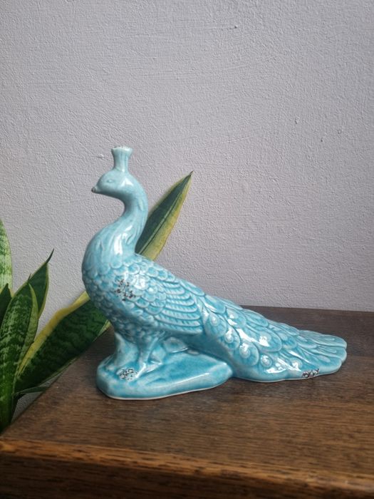 ceramiczna figurka pawia w kolorze turkusowym.