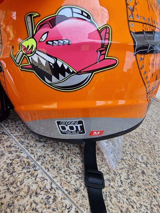 capacete de motocross laranja e amarelo com gráficos de dentes de tubarão