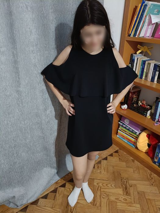 Vestido preto elegante com ombros descobertos e mangas fluídas