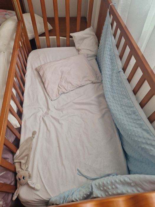 Berço com roupa de cama e mobile.