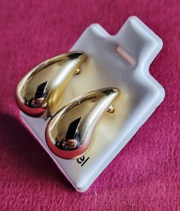 Pequenos brincos dourados, em aço, em forma de gota. De pico