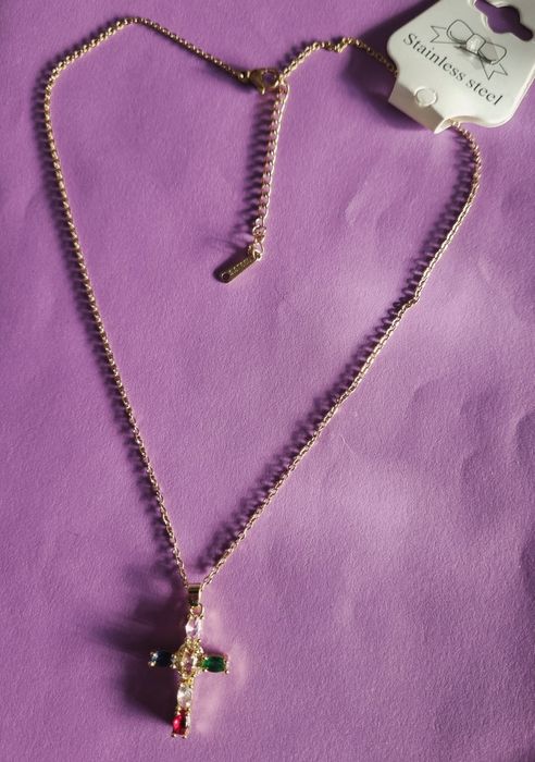 Colar dourado, em aço, com cruz colorida. Tem extensor.