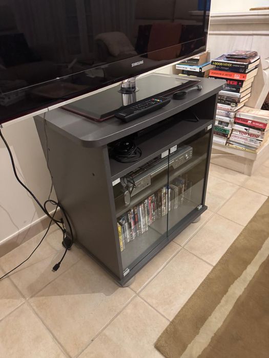 Móvel de TV cinzento com pés metalizados e portas de vidro