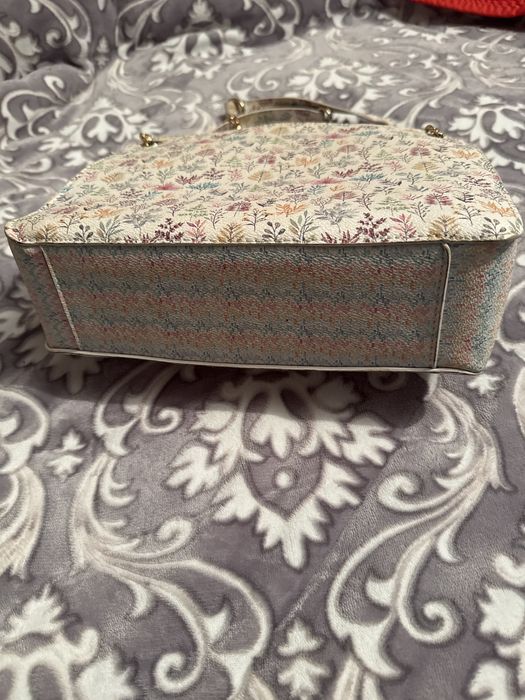 Mala a tiracolo branca com padrao colorido.