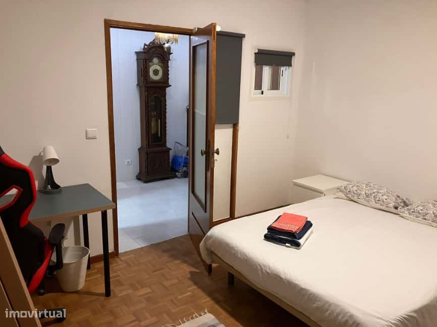 Spacious bedroom with a double bed, a desk and a couch